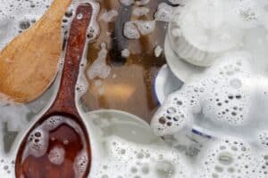 Dishes and bowls in water and bubbles of dishwashing liquid