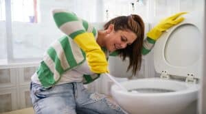 Scrubbing and cleaning. Shot of a young woman cleaning a bathroom toilet